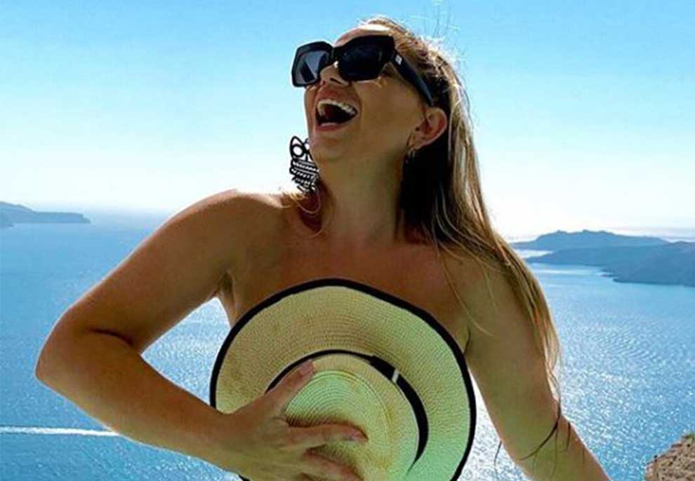Rozana Radi mbulon gjoksin me kapele në Santorini